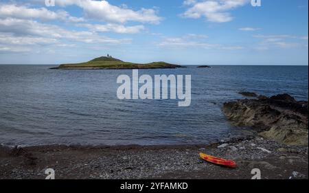 Felsküste aus Bellycotton mit Leuchtturm für die Meeressicherheit in Irland. Atlantischer Ozean bewölkter Himmel Stockfoto