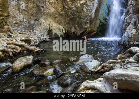 Unbekannte Frau schwimmt im natürlichen Pool der Millomeri Wasserfälle Platres, Troodos, Zypern, Europa Stockfoto