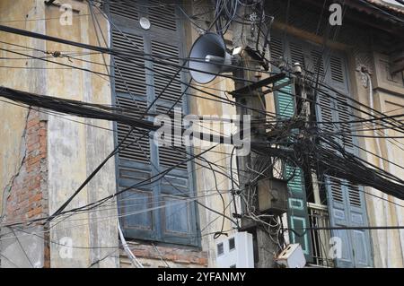 Unordentlicher verwickelter Strom, Telekommunikationsdrähte, Kabel an Masten in Hanoi, Vietnam, Asien Stockfoto