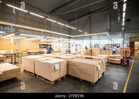 Eine große Holzbearbeitungsfabrik mit Stapeln frisch geschnittener Holzplatten, die für die Verarbeitung bereit sind und industrielle Effizienz und Präzision in einer guten Hand zeigen Stockfoto