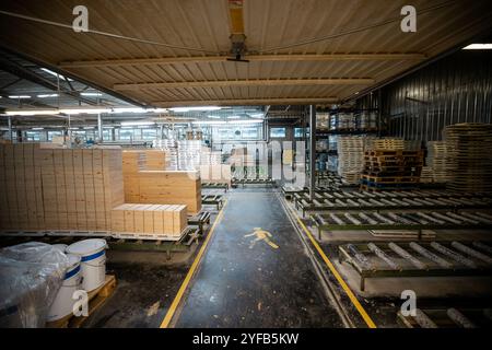 Eine große Holzbearbeitungsfabrik mit Stapeln frisch geschnittener Holzplatten, die für die Verarbeitung bereit sind und industrielle Effizienz und Präzision in einer guten Hand zeigen Stockfoto