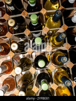 Reihen Rot- und Weißwein in einem modernen Holzregal Stockfoto