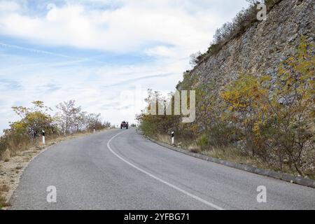 Dichte Waldberglandschaft im Sommer mit kurviger Straße, die durch den Wald führt Stockfoto