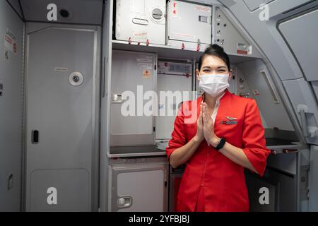 BANGKOK, THAILAND - 26. OKTOBER 2023: Eine weibliche Flugbegleiterin in Uniform in AirAsia. Stockfoto