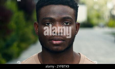 Bewegende Aufnahme ernsthafte birassische ethnische männliche Blick auf die Kamera Afroamerikaner Mann in der Stadt lächelnd glückliche Show hohe zufriedene Finger gute Geste zeigen Stockfoto