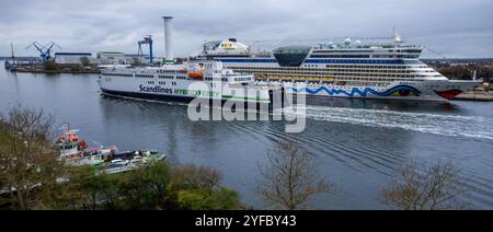 Rostock, Deutschland. November 2024. Die Fähre „Berlin“ passiert das Kreuzfahrtschiff „Aida diva“ durch den vertieften Meereskanal. Seit Oktober 2022 vertiefen Spezialbagger den rund 16 Kilometer langen Meereskanal. Dies kann nun von Schiffen mit einer Tieftiefe von bis zu 15 Metern genutzt werden. Quelle: Jens Büttner/dpa/Alamy Live News Stockfoto