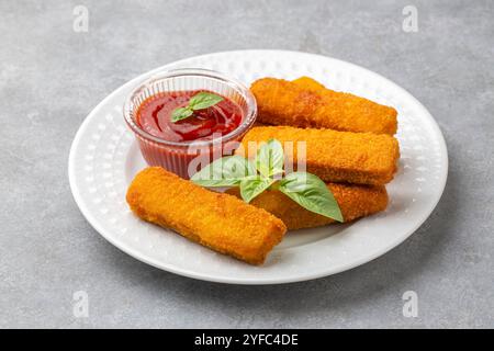 Fish and Chips. Nahaufnahme von knusprigen panierten, frittierten Fischfingern mit Brotkrumen, serviert mit Remoulade-Sauce und Zitrone Stockfoto