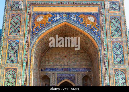 Tigermosaiken am gewölbten Eingang zur Sher-Dor (Having Tigers) Madrasah. Das Sher-Dor Madrasah ist Teil des Ensemble of Registan im historischen Zentrum Stockfoto