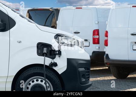 Elektrische Lieferwagen mit Ladestation für Elektrofahrzeuge. Stockfoto