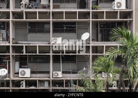 Bangkok, Thailand - 27. Februar 2023 - mehrstöckiges altes Betonwohnhaus mit Fenstergruppen auf Balkonen. Unterbringung der unansehnlich heruntergekommenen Armen Stockfoto