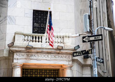 Der Eckeingang der New Yorker Börse mit amerikanischer Flagge und Wall Street-Schildern. Stockfoto