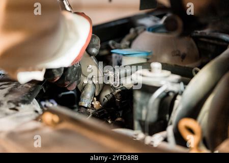 Kfz-Mechaniker, der an der Reparatur von Motorteilen arbeitet. Stockfoto