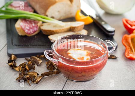 Fastenborsch mit getrockneten Pilzen und Gemüse auf einem hellen Holztisch. Stockfoto