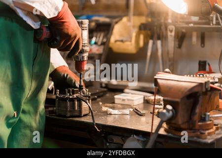 Handwerkskunst in Aktion: Ein erfahrener Techniker, der die Maschinen in einer Werkstatt wiederbelebt. Stockfoto