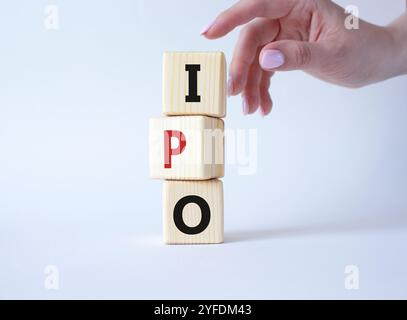 IPO – Symbol für erstes öffentliches Angebot. Konzeptwort IPO auf Holzwürfeln. Geschäftsmann Hand. Schöner weißer Hintergrund. Business- und IPO-Konzept. Kopie sp Stockfoto