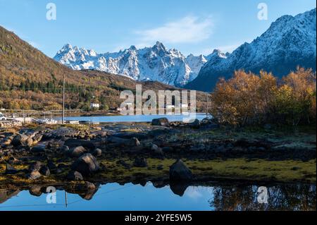 Herbstblick von der Autobahn E10 des Austnesfjorden und Vestpollen mit dem schneebedeckten Berg Higravtindan, ist er der höchste Berg auf der Insel Stockfoto