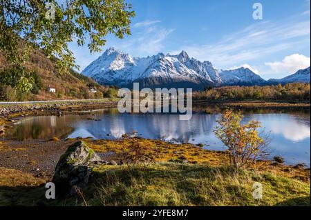 Herbstblick von der Autobahn E10 des Austnesfjorden und Vestpollen mit dem schneebedeckten Berg Higravtindan, ist er der höchste Berg auf der Insel Stockfoto