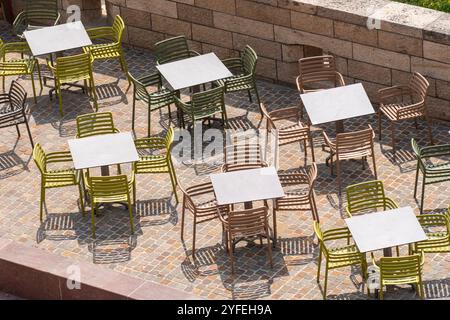 Terrasse im Freien mit farbenfrohen leeren Tischen und Stühlen, fotografiert von oben Stockfoto