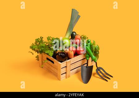 Frisch geerntetes Gemüse in einer Holzkiste auf hellem Hintergrund Stockfoto