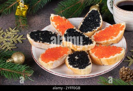 Hausgemachte Sandwiches mit rotem und schwarzem Kaviar auf weißem Brot Toast auf runder Platte Stockfoto