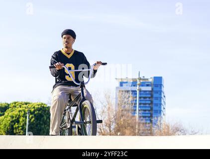 Porträt eines jungen Afroamerikaners mit einem Trial-Bike in einem Skatepark in einer Stadt Stockfoto