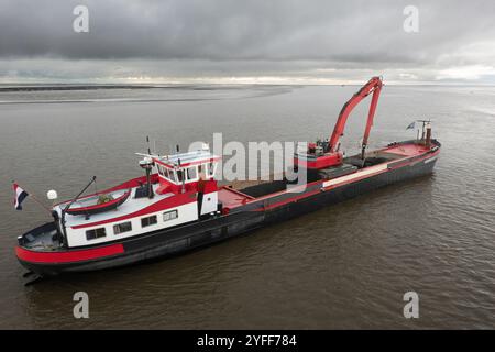 Red Baggerarbeiten Schiff arbeiten am Meer, Entfernen von Ablagerungen in einer Wasserstraße Stockfoto