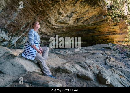 Eine Wanderer ruht sich in einer kleinen Grotte in der Red River Gorge in Kentucky aus Stockfoto