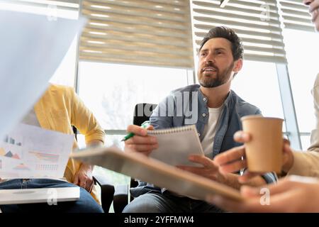 Kreative Geschäftsleute sammeln Brainstorming, diskutieren Ideen und analysieren Diagramme während einer Besprechung im Büro Stockfoto