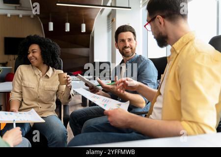 Gruppe von Geschäftsleuten, die sich in einem modernen Büro treffen, um Finanzdokumente zu analysieren und eine neue Strategie für den Start eines Projekts zu diskutieren Stockfoto