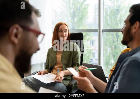 Das Team junger Fachkräfte führt ein produktives Meeting im Konferenzraum durch, erarbeitet ein Brainstorming und teilt seine Ideen mit Stockfoto