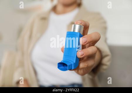 Frau hält Inhalator drinnen, Nahaufnahme. Asthmabehandlung Stockfoto