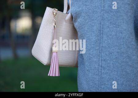 Frau mit rosa Leder Schlüsselanhänger an ihrer Tasche draußen, Nahaufnahme Stockfoto