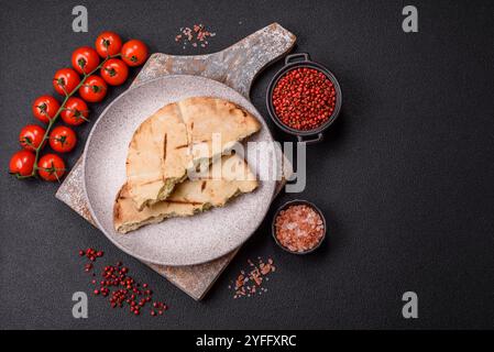 Rundes Fladenbrot oder Pita mit Käse, Kräutern, Salz und Gewürzen, auf dem Grill gebacken Stockfoto