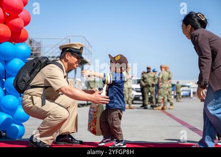 San Diego, Kalifornien, USA. Oktober 2024. Jan Jazon Delacruz, der dem Amphibienschiff USS Harpers Ferry (LSD 49) zugeteilt wurde, umarmt seinen Sohn am Pier der Marinebasis San Diego am 18. Oktober 2024. Nach einem siebenmonatigen Einsatz in den Einsatzgebieten der 7. Und 3. Flotte kehrten die Segler der Harpers Ferry nach San Diego zurück. (Kreditbild: © U.S. Navy/ZUMA Press Wire) NUR REDAKTIONELLE VERWENDUNG! Nicht für kommerzielle ZWECKE! Stockfoto