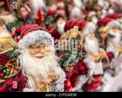 Viele Weihnachtsmannpuppen im Kostüm mit langem weißem Bart. Weihnachten und Neujahr traditionelle Dekoration. Unbelegter Hintergrund. Stockfoto