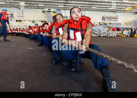 Auf See. Oktober 2024. Seemänner der US-Navy fliegen in der Hangarbucht des Flugzeugträgers USS Abraham Lincoln (CVN 72) der Nimitz-Klasse während einer Auffüllung auf See mit dem Trockenfrachtschiff USNS Amelia Earhart (T-AKE 6). (Kreditbild: © U.S. Navy/ZUMA Press Wire) NUR REDAKTIONELLE VERWENDUNG! Nicht für kommerzielle ZWECKE! Stockfoto