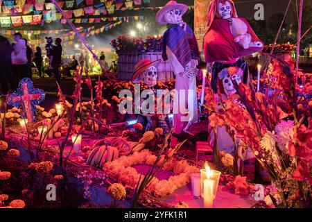 Dia de Muertos-Altar mit Skeletten, Ringelblöcken, Kerzen und Opfergaben, feiert die mexikanische Kultur und ehrt die Verstorbenen. Beleuchtete Ofrenda Stockfoto