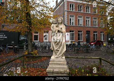 Maria mit Kinderstatue (Inschrift Het Gebuurte 1904) vor der Kirche St. Magdalena – Brügge, Belgien – 21. Oktober 2024 Stockfoto