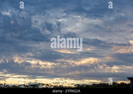 Dramatischer Sonnenuntergangshimmel mit Wolkenschichten und blauen und rosa Highlights über Wolken. Stockfoto