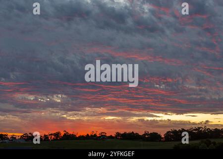 Dramatischer Sonnenuntergangshimmel mit Wolkenschichten und blauen und rosa Highlights über Wolken. Stockfoto