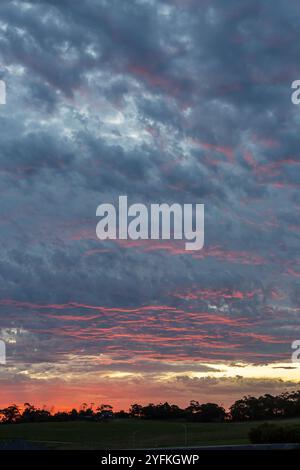 Dramatischer Sonnenuntergangshimmel mit Wolkenschichten und blauen und rosa Highlights über Wolken. Stockfoto