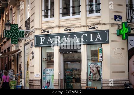 VALENCIA, SPANIEN - 13. OKTOBER 2024: Der Eingang zu einer spanischen Apotheke (farmacia) ist in Valencia mit dem traditionellen grünen Kreuz gekennzeichnet. Stockfoto