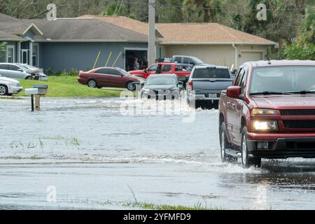 Überflutete Stadtstraße mit fahrenden Autos unter Wasser in Florida Wohngebiet nach dem Sturm Ian Landung. Folgen von Naturkatastrophen. Stockfoto