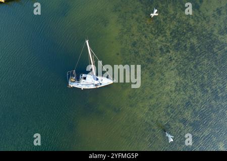Luftaufnahme des versunkenen Segelbootes auf flachen Gewässern der Bucht nach dem Hurrikan in Manasota, Florida. Stockfoto