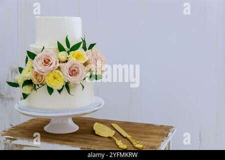 Weiße Hochzeitstorte mit frischen Blumen und Kerzen. Stockfoto