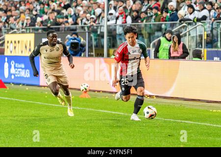 Warschau, Polen. November 2024. Ryoya Morishita (R) von Legia und Hilary Gong (L) von Widzew ?odz werden während des Polnischen PKO Ekstraklasa League-Spiels zwischen Legia Warszawa und Widzew ?odz im Marschall Jozef Pilsudski Legia Warschau Municipal Stadium gesehen. Endpunktzahl 2:1 Credit: SOPA Images Limited/Alamy Live News Stockfoto