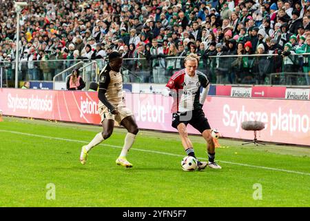 Warschau, Polen. November 2024. Hilary Gong (L) von Widzew ?odz und Wojciech Urbanski (R) von Legia werden während des Polnischen PKO Ekstraklasa League-Spiels zwischen Legia Warszawa und Widzew ?odz im Marschall Jozef Pilsudski Legia Warschau Municipal Stadium gesehen. Endpunktzahl 2:1 Credit: SOPA Images Limited/Alamy Live News Stockfoto