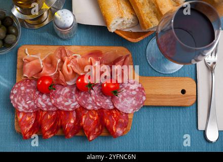 Spanische leckere Mahlzeit Würste und Jamon mit Tomaten schneiden, Nahaufnahme Stockfoto