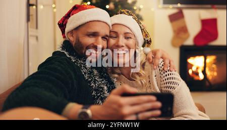 Weihnachten, Happy und Selfie von Paaren zu Hause Foto für Profilfotos, Social Media Post und Erinnerung. Liebe, Bindung und Mann und Frau umarmen sich Stockfoto
