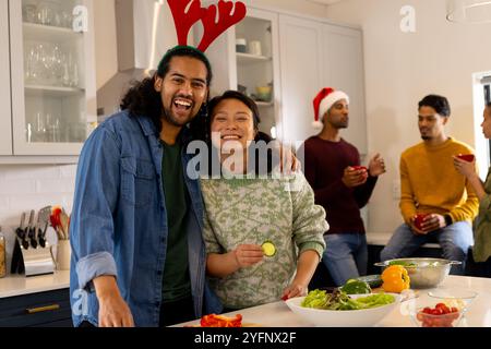 Multirassische Freunde feiern weihnachten in der Küche, bereiten Salat zu Hause vor Stockfoto